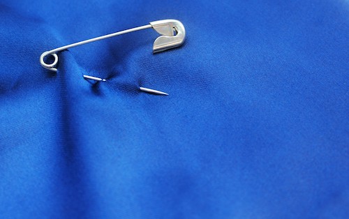 open and closed safety pin on white background